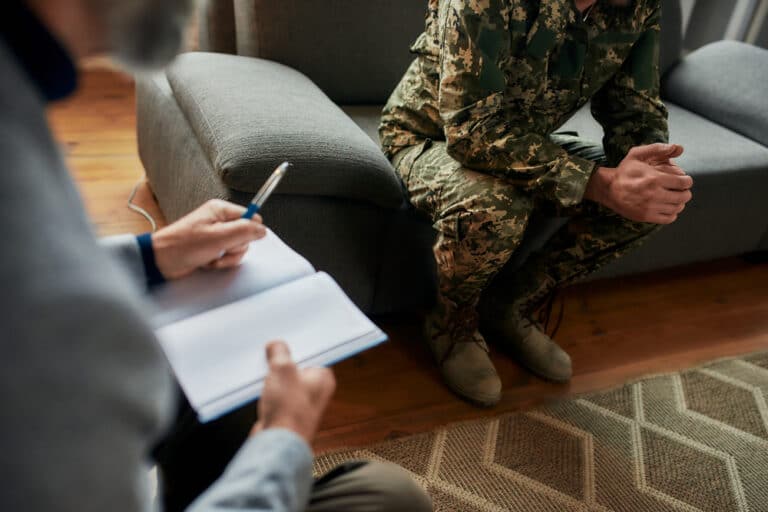 Cropped shot of a military man in uniform in a therapy session with a psychologist